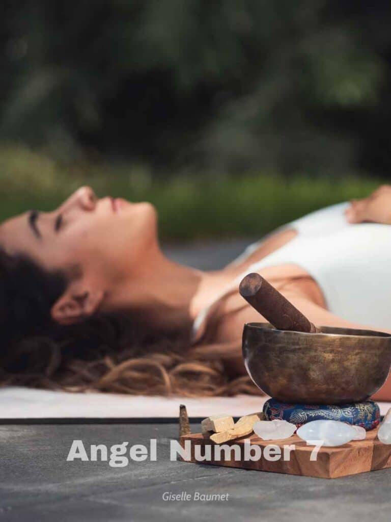 A spiritual woman laying down next to a chime bowl and in nature.